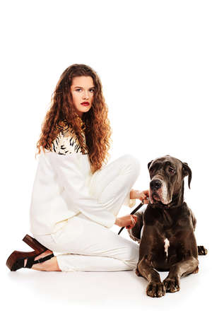 Beautiful young woman posing with her Great Dane dog. Isolated over white.の写真素材