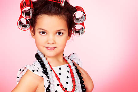 Portrait of a cute little pin-up girl over pink background.の写真素材