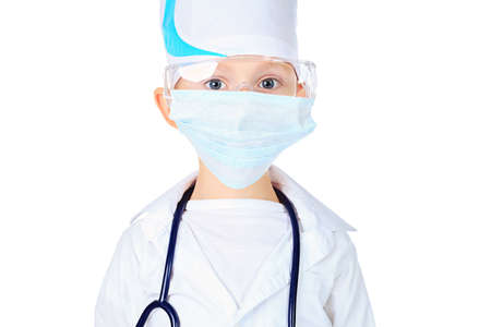 Portrait of a cute boy in mask playing doctor with a stethoscope. Isolated over white.の写真素材