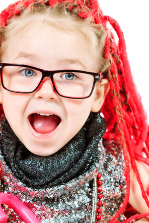Portrait of a trendy little girl wearing red braids and modern clothes.