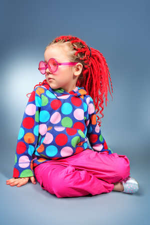 Portrait of a trendy little girl wearing red braids and modern clothes.の写真素材