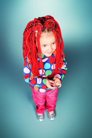 Portrait of a trendy little girl wearing red braids.の写真素材