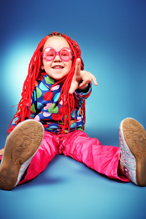 Portrait of a trendy little girl wearing red braids and modern clothes.の写真素材