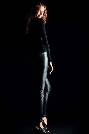 Charming fashion model with beautiful curly hair posing at studioの写真素材