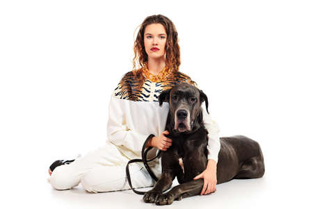 Beautiful young woman posing with her Great Dane dog. Isolated over white.の写真素材