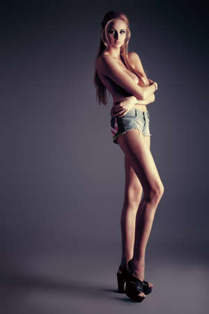 Full length portrait of an attractive naked woman posing at studio.の写真素材