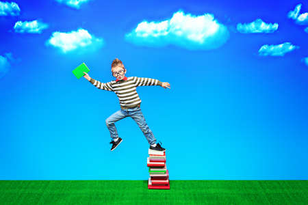 A boy with a book in hand is flying to knowledgeの写真素材