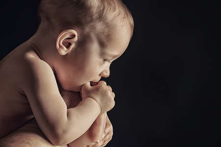 Portrait of beautiful baby. Over black background.の写真素材