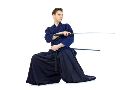 Handsome young man practicing kendo. Isolated over white.