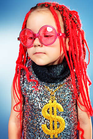 Portrait of a trendy little girl wearing red braids and pink sunglasses.の写真素材