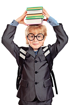 Portrait of a happy schoolboy in glasses holding a stack of books. Isolated over white background.の写真素材