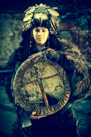 Portrait of a shaman with a drum outdoor. 