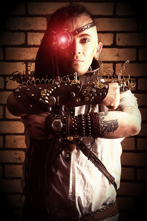 Portrait of a steampunk man with a mechanical devices over brick wall.の写真素材