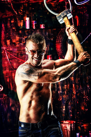 Handsome muscular man with sledgehammer working in the old garage.の写真素材