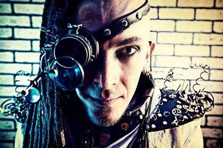 Portrait of a steampunk man with a mechanical devices over brick wall.の写真素材