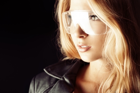 Stunning blonde woman in black leather jacket over dark background.の写真素材