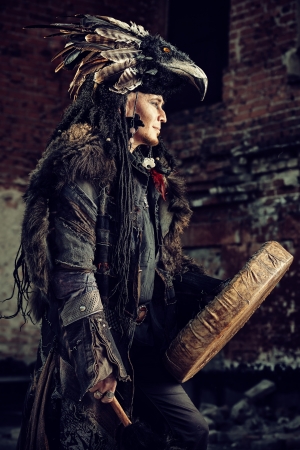 Portrait of a shaman dancing with a drum outdoor. の写真素材