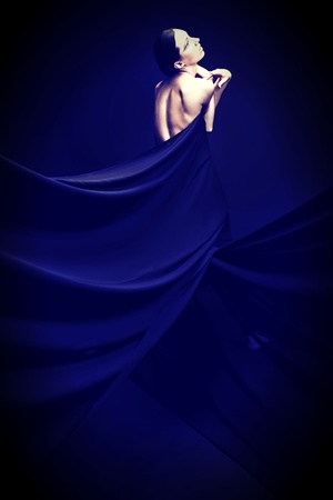Art fashion photo of a beautiful woman in black dress. Over black background.の写真素材