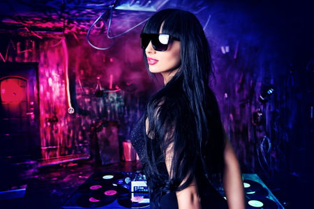 Beautiful sexy DJ girl working on a party in the old garage.の写真素材