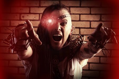 Portrait of a steampunk man with a mechanical devices over brick wall.の写真素材