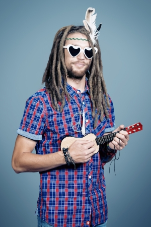 Portrait of a hippie young man playing his guitar.の写真素材