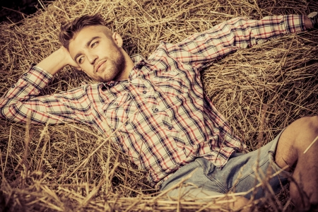 Handsome young man lying in haystack.の写真素材
