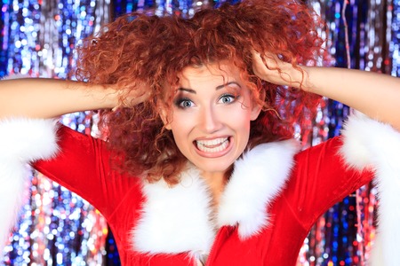 Attractive young woman in Christmas clothes on a party. Disco lights in the background.の写真素材
