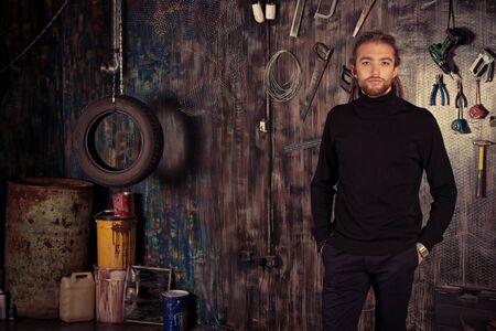 Confident handsome man in the old garage.の写真素材