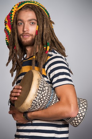 Portrait of a rastafarian guy playing his drum.の写真素材