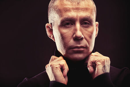 Close-up portrait of a man over black background.の写真素材