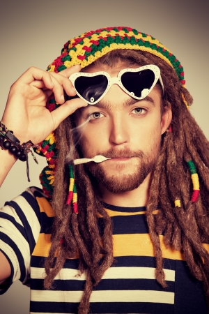 Portrait of a happy rastafarian young man listening to music in headphones.の写真素材