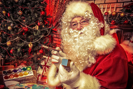 Santa Claus making Christmas gifts at home.の写真素材