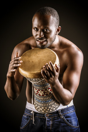 African american man posing with his drum. Over black background.の写真素材