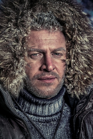 Portrait of a handsome brutal man dressed in winter clothes, covered with frost.の写真素材