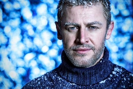 Portrait of a handsome brutal man dressed in winter clothes, covered with frost.の写真素材