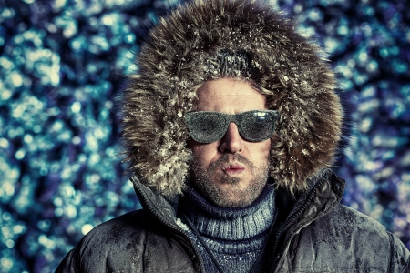 Handsome brutal man dressed in winter clothes covered with frost. の写真素材