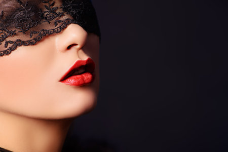 Close-up portrait of a charming  woman in black lace mask.の写真素材