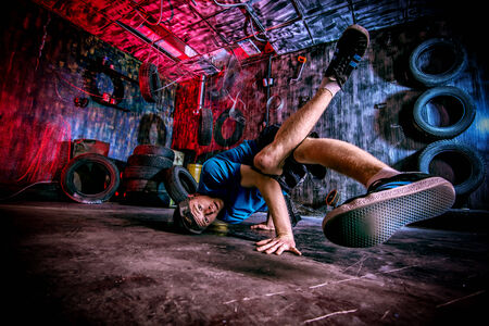 Trendy young man dancer dancing in the old garage.の写真素材