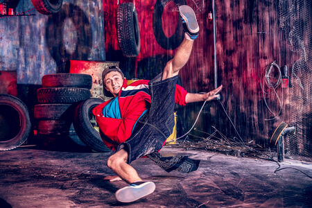 Trendy young man dancer dancing in the old garage.の写真素材