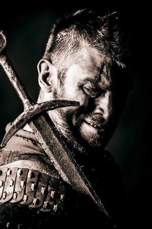 Portrait of a courageous ancient warrior in armor with sword.の写真素材