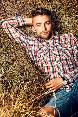 Handsome young man lying in haystack.の写真素材
