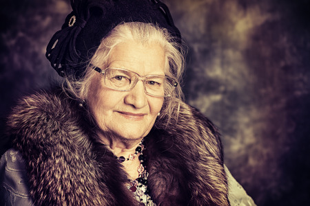 Portrait of a beautiful old lady in an elegant old-fashioned clothes. Vintage style.の写真素材