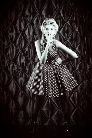 Full length portrait of a charming pin-up woman with retro hairstyle and make-up.の写真素材