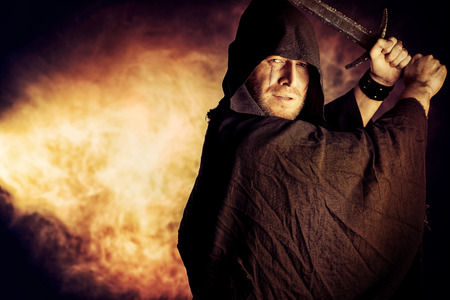 Portrait of a courageous warrior wanderer in a black cloak and sword in hand. Historical fantasy.の写真素材