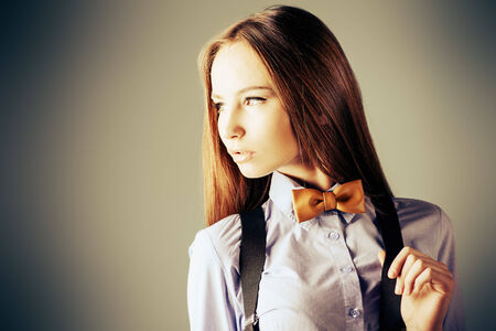 Elegant girl model poses in blouse and bow tie. Fashion shot. の写真素材