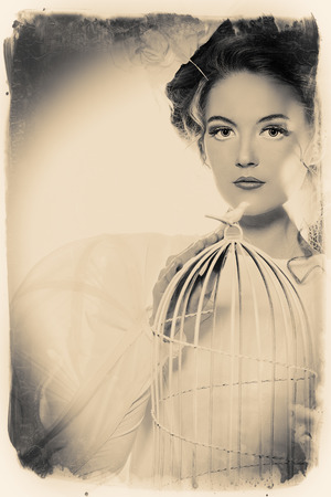 Beautiful fashion model in the refined white dress and elegant hat. Vintage style. Art project.の写真素材