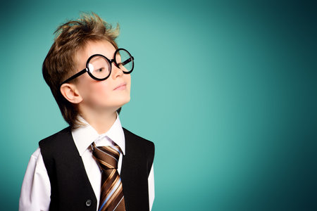 Portrait of a cute smart boy wearing suit and spectacles. Education. Studio shot.