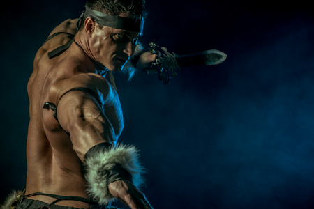 Portrait of a handsome muscular ancient warrior with a sword.の写真素材