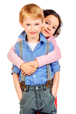 Portrait of a happy little girl embracing a cute boy. Children. Isolated over white.の写真素材