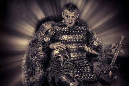 Portrait of a courageous ancient warrior in armor with sword and shield. Black-and-white photo.の写真素材